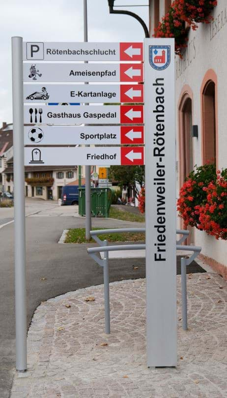 Tourismus-Wegweiser mit Stadtnamen-Stele mit Wappen