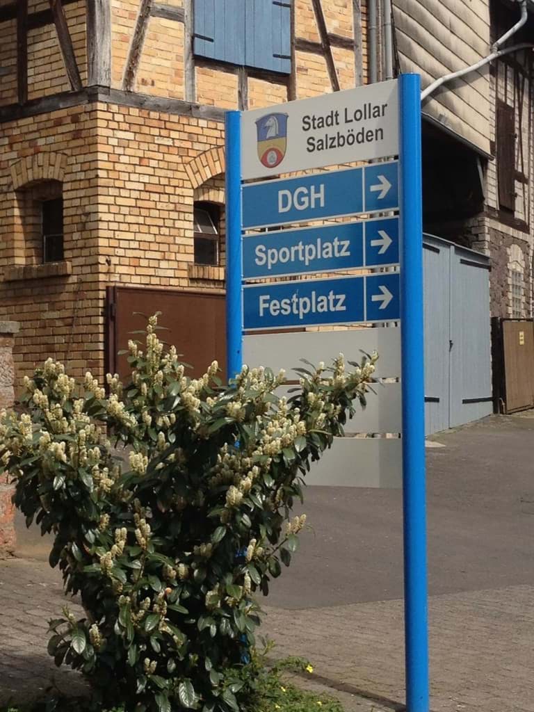 Wegweiser als Teil einer kommunalen Beschilderung mit Richtungsangaben für Sport- & Festplatz Wegweiser als Teil einer kommunalen Beschilderung mit Richtungsangaben für Sport- & Festplatz