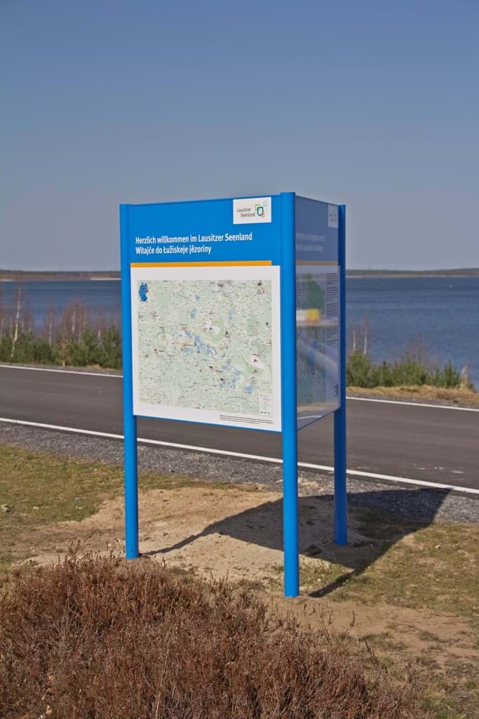 Eine im Dreieck aufgestellte Infotafel mit farbig lackierten, einbetonierten Pfosten Eine im Dreieck aufgestellte Infotafel mit farbig lackierten, einbetonierten Pfosten
